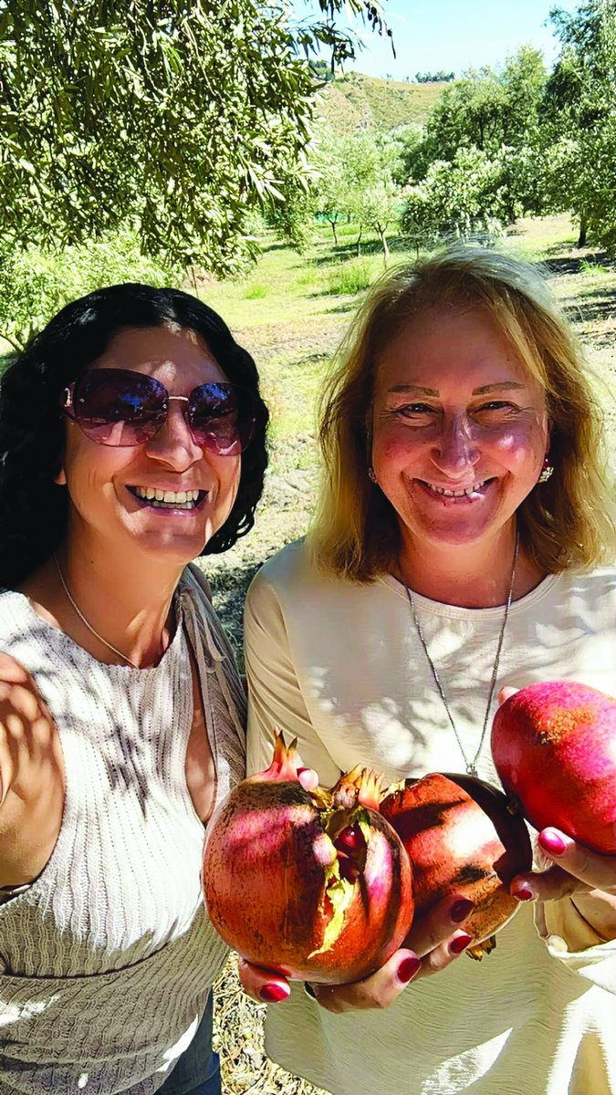 Annamaria con un'amica tra i melograni del territorio di Cleto